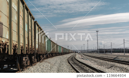 Panorama railroad tracks with wagons and railway transport. View to railway station with railroad tracks with wagons. Loading railway cars. Railway wagons standing at the station waiting for loading 119664934
