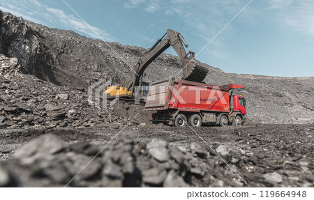 Large quarry dump truck and excavator. Big mining truck work coal deposit. Loading coal into body truck. Production useful minerals. Mining mining machinery to transport coal from open-pit production 119664948