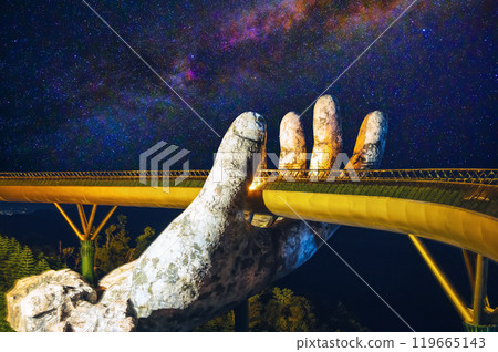 Golden Bridge or Hand of Gods at the Sun World Ba Na Hills entertainment park in Da Nang in Vietnam at night under starry sky Golden Bridge or Hand of Gods at the Sun World Ba Na Hills entertainment park in Da Nang in Vietnam at night under starry sky 119665143