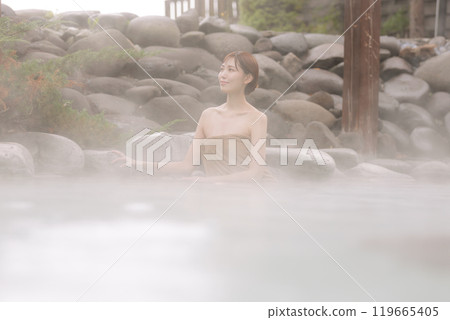 A young woman taking a leisurely open-air bath 119665405