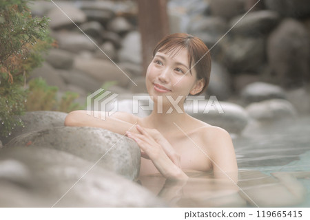 A young woman taking a leisurely open-air bath A young woman taking a leisurely open-air bath 119665415