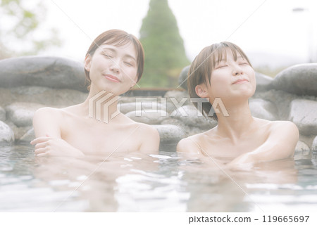 Young women relaxing in an open-air bath Young women relaxing in an open-air bath 119665697