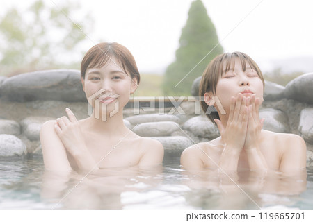 Young women relaxing in an open-air bath Young women relaxing in an open-air bath 119665701