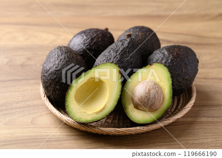 Ripe Hass avocado fruit in basket on wooden background 119666190
