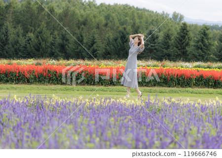 A woman walking through a flower field A woman walking through a flower field 119666746