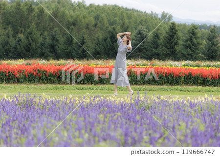 A woman walking through a flower field A woman walking through a flower field 119666747