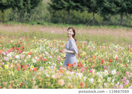 A woman happily strolling through a flower field 119667089