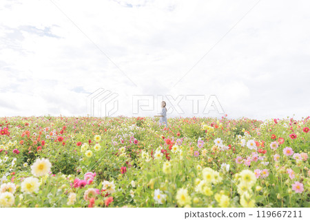 A woman happily strolling through a flower field 119667211