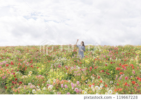 A woman happily strolling through a flower field 119667228