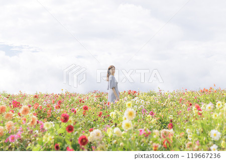 A woman happily strolling through a flower field 119667236