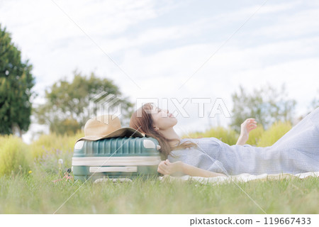 A woman lying down on the lawn A woman lying down on the lawn 119667433