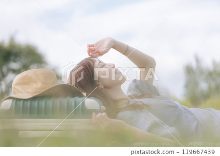 A woman lying down on the lawn A woman lying down on the lawn 119667439