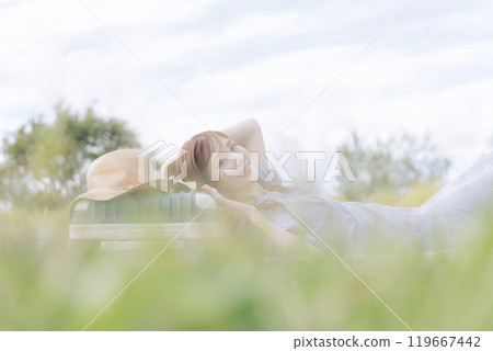 A woman lying down on the lawn A woman lying down on the lawn 119667442