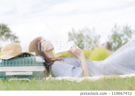 A woman lying down on the lawn A woman lying down on the lawn 119667452