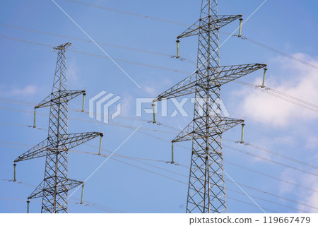 High voltage towers with sky background. Power line support with wires for electricity transmission. High voltage grid tower with wire cable at distribution station. Energy industry, energy saving 119667479