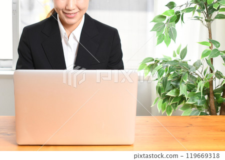 穿著西裝的年輕女子使用筆記型電腦 穿著西裝的年輕女子使用筆記型電腦 119669318