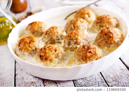 Baked chicken balls, meat balls with white sauce and cheese Baked chicken balls, meat balls with white sauce and cheese 119669380