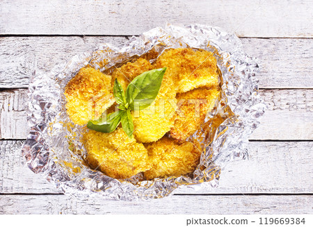 Homemade golden chicken Nuggets, on foil with Ketchup sauce 119669384