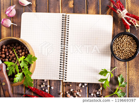 Open recipe book with fresh herbs and spices Open recipe book with fresh herbs and spices 119669397