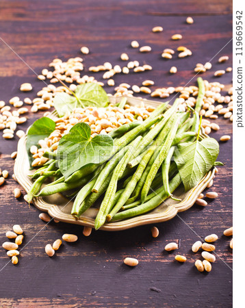 Heap of green pods of raw, not cooked, asparagus beans and white beans on a table 119669542