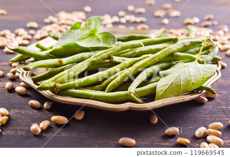 Heap of green pods of raw, not cooked, asparagus beans and white beans on a table Heap of green pods of raw, not cooked, asparagus beans and white beans on a table 119669545