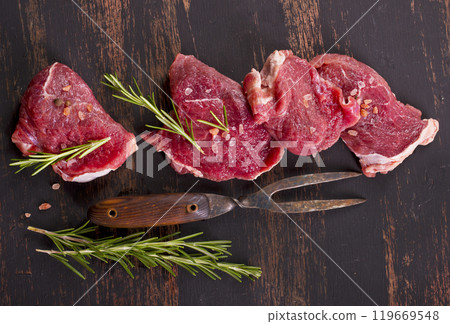 raw beaf on a dark wooden table. 119669548