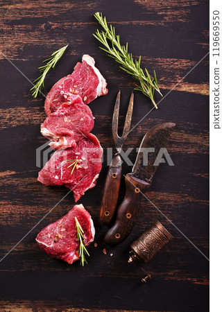 raw beaf on a dark wooden table. 119669550