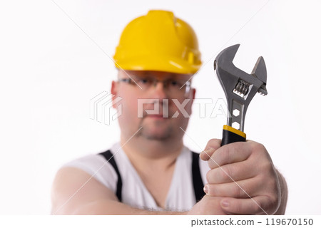 A Construction Worker Holding an Adjustable Wrench, Showcasing Skills and Dedication 119670150