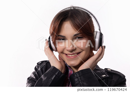 A Joyful Girl Happily Enjoying Her Favorite Music While Wearing Headphones and Smiling 119670424