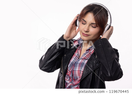 A Young Woman is Enjoying Her Favorite Music with Stylish Headphones in a Modern Style A Young Woman is Enjoying Her Favorite Music with Stylish Headphones in a Modern Style 119670445