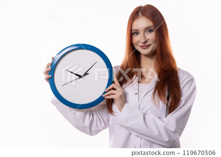 A Woman is Holding a Clock While Wearing a Lab Coat in an Official Professional Setting 119670506