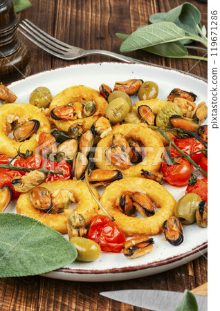 Grilled mussels with herbs and squid rings. 119671286
