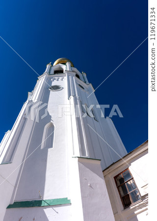 Bell tower of the Vologda Kremlin. A majestic structure with a golden dome against the blue sky. 119671334