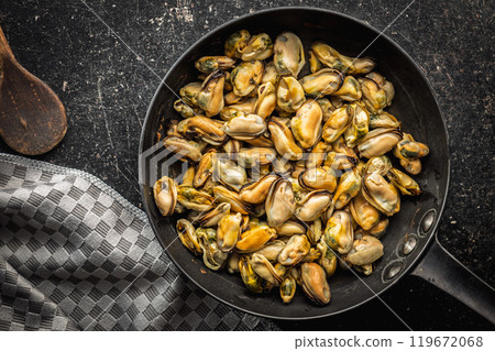 Shelled mussels meat in pan on black table. Top view. 119672068