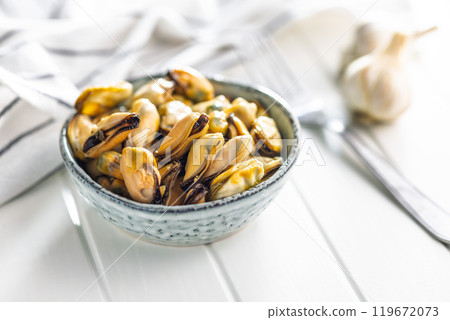 Shelled mussels meat in bowl on white table 119672073