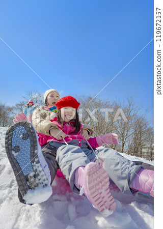 Parents and children sledding in a snowy park 119672157