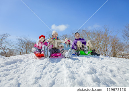 一家四口在白雪皚皚的公園裡滑雪橇 一家四口在白雪皚皚的公園裡滑雪橇 119672158