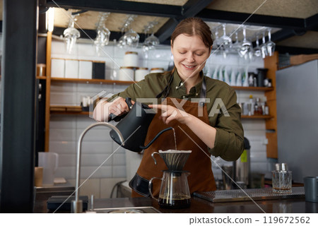 Barista hands pouring boiling water into filter coffee pot 119672562
