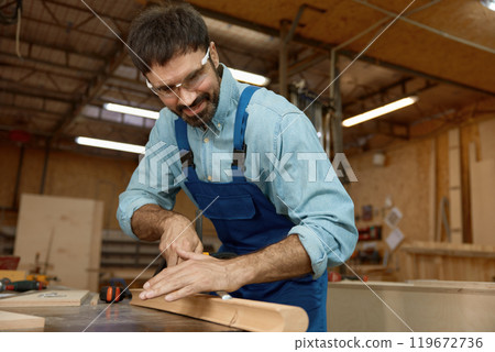 Experienced woodworker using chisel at well-equipped carpentry workshop Experienced woodworker using chisel at well-equipped carpentry workshop 119672736