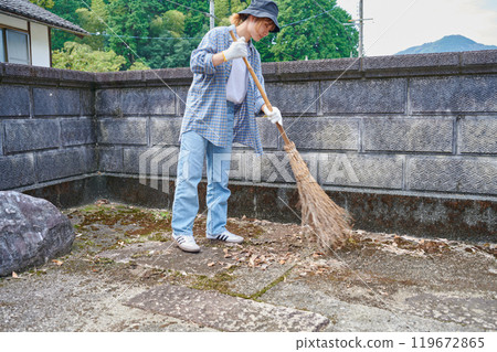 Woman sweeping the garden Countryside Old house Inn Life 119672865