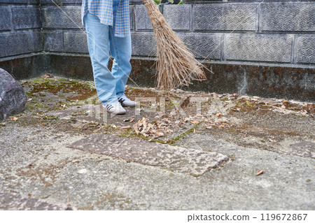 Woman sweeping the garden Countryside Old house Inn Life 119672867