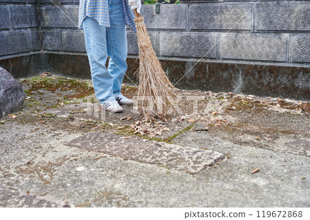 Woman sweeping the garden Countryside Old house Inn Life 119672868