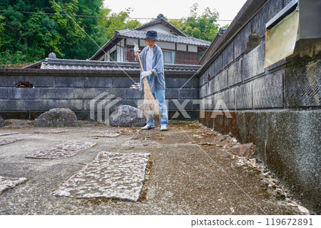 Woman sweeping the garden Countryside Old house Inn Life 119672891