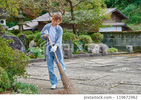 Woman sweeping the garden Countryside Old house Inn Life 119672962