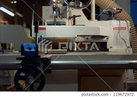 Thickness planer machine to trim wood plank closeup view, woodworking workshop Thickness planer machine to trim wood plank closeup view, woodworking workshop 119672972