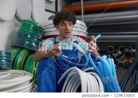 Crazy plumber shouting while sitting at plumbing shop floor 119673005