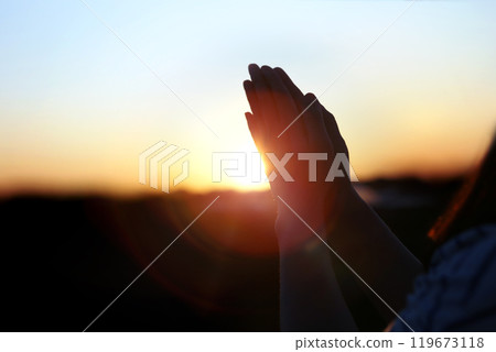 New Year sunrise rising sun background and shining light through praying christian hands, future hope and wish concept 119673118