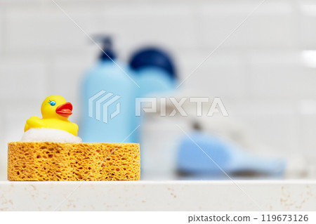 Yellow rubber duck, soap, bath foam on bath background, baby bath accessories 119673126