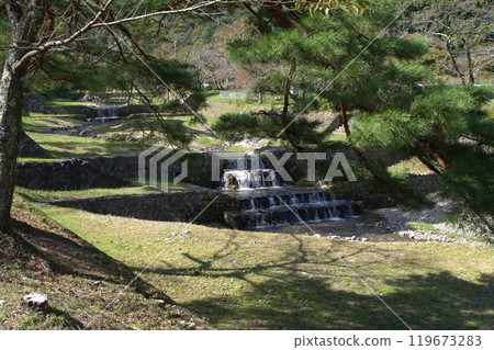 Landscape with a small stepped waterfall Landscape with a small stepped waterfall 119673283
