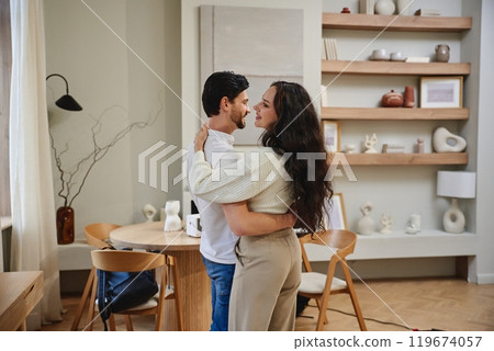 A couple enjoys a cozy moment together in a stylish living room A couple enjoys a cozy moment together in a stylish living room 119674057